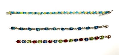 four different colored bracelets are shown on a white surface