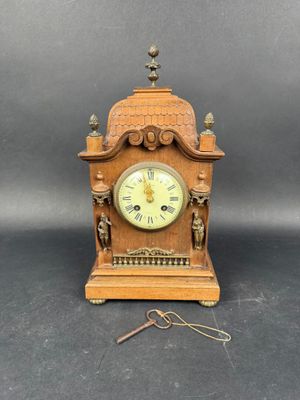 une vieille horloge en bois posée sur une table, à côté d'une ficelle