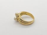 a close up of a gold ring with pearls on a white surface