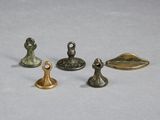 four pieces of bronze are shown on a white surface