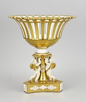 une photo d'un vase doré et blanc posé sur une table