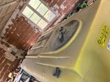a yellow refrigerator sitting in a room with a brick wall