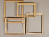 quatre cadres en bois sont disposés en rangée sur un mur