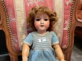 a doll that is sitting on a chair with a tag on it