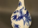 a blue and white vase with a bird on it