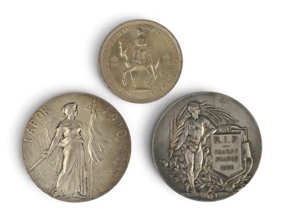 three silver coins, one of which is a woman and one of which is a man