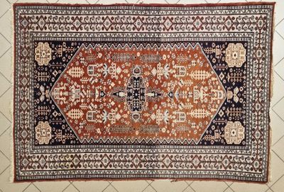 a close up of an oriental rug on a tiled floor