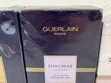two boxes of perfume sitting next to each other on a table