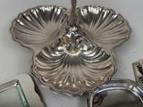 a silver plate with a spoon and a mirror on the table