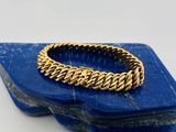 un gros plan d'un bracelet en or orné d'une pierre bleue