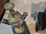 a small metal object on a table next to a clock