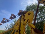 a yellow crane that is sitting in the grass