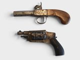 two old revolvers that are on display on a white surface