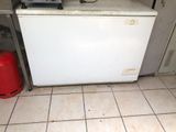 a small white refrigerator in the corner of a kitchen