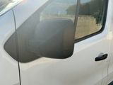 une camionnette blanche garée sur un parking à côté d'un bâtiment
