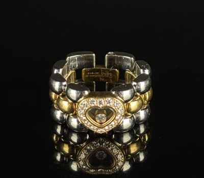 une image représentant un bracelet en or et en argent posé sur une surface noire