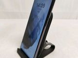 a close up of a cell phone on a stand on a table