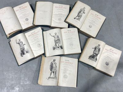 several open books on a table with a statue in the middle of them