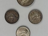 four different types of coins are shown on a white surface