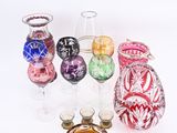 de nombreux vases en verre de différentes couleurs posés sur une surface blanche