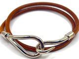 bracelet en cuir marron avec un fermoir argenté sur fond blanc