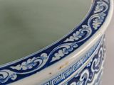 a blue and white vase with a mirror in it