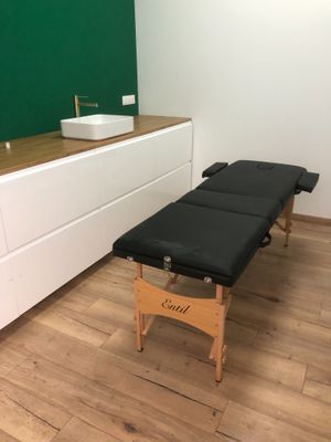 une photo d'une pièce avec une table de massage et un lavabo
