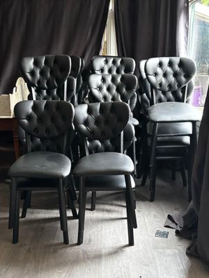 beaucoup de chaises noires qui sont disposées dans une pièce
