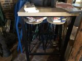 a table with three stools and a bag on it