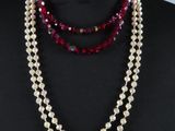 un gros plan sur un mannequin portant un collier de perles rouges et blanches