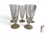 three empty wine glasses sitting next to each other on a white surface