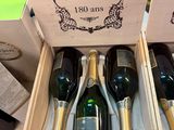 Plusieurs bouteilles de champagne se trouvent dans une caisse en bois posée sur une table