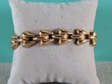 un gros plan d'un bracelet en or posé sur un oreiller