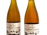 deux bouteilles de vin posées l'une à côté de l'autre sur une surface blanche