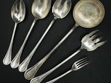 six cuillères en argent et deux cuillères en argent sur un fond noir