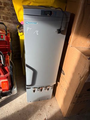 a small refrigerator next to a stack of boxes in a room