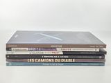 three books stacked on top of each other on a white surface