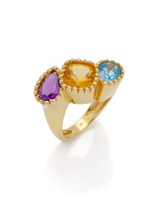 gros plan d'une bague en or avec trois pierres de couleurs différentes