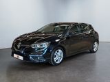 a black car parked in a room with a white wall