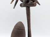 sculpture en bois représentant deux pélicans perchés sur un arbre, avec un œuf au premier plan