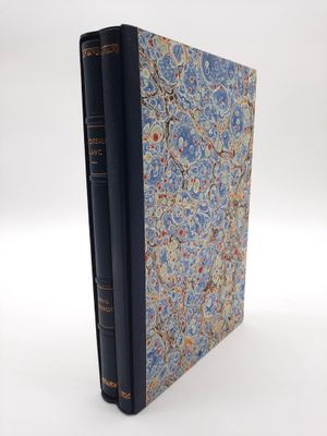 un vieux livre à la couverture bleue posé sur une table blanche