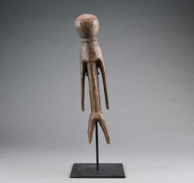 une sculpture en bois représentant un oiseau, posée sur un socle noir