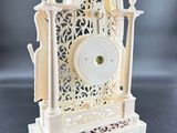a white clock that is sitting on a table