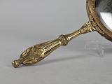 brass plated magnifying mirror with ornate handle on stand