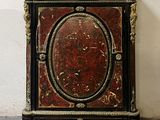a red and black cabinet with gold decorations on it