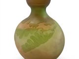 a green and yellow vase on a white surface