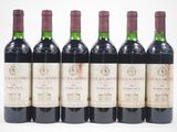 six bouteilles de vin sont alignées sur une surface blanche