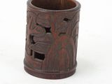 a wooden cup with carvings on it on a white surface