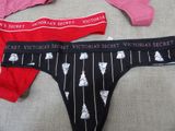 three pairs of victoria ' s secret underwear sitting on a bed