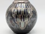a black and silver vase with geometric designs on it